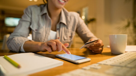 Close-up of woman e-banking in the evening at home.